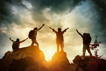 Celebrating life of Hikers climbing up mountain cliff. Climbing group helping each other while...