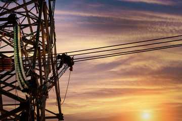 Worker wiring electric power on steel tower,  Electric construction and maintenance services...