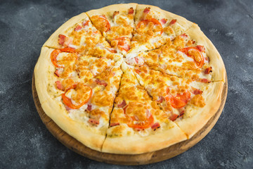 Italian pizza with bacon, cheese and tomato
