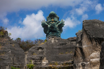 impressive view of Garuda Wisnu green copper statue inspired in Hindu myth standing majestic under a blue sky in Indonesia travel destination landmark