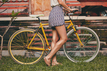 Pretty woman sitting with old bicycle outdoors.