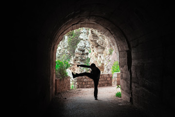 Man practicing karate moves in a tunnel