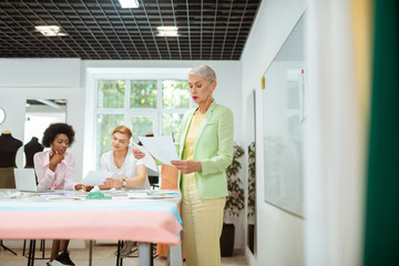 Concentrated fashion designer standing at a cutting table