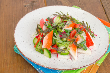 Fresh vegetable salad with crab sticks. 