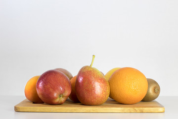 red Apple, pear, lemon, orange, kiwi, peach on white background, copy space