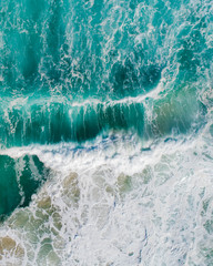 Aerial view of a waves crashing and rolling in the ocean.