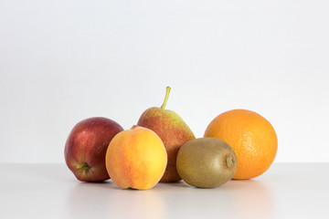 red Apple, pear, lemon, orange, kiwi, peach on white background, copy space