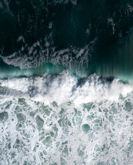 Aerial view of a waves crashing and rolling in the ocean.