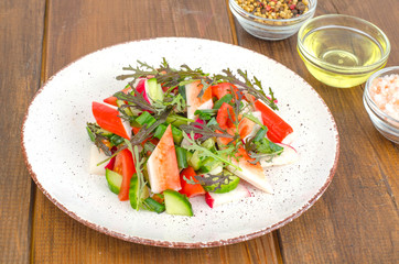 Fresh vegetable salad with crab sticks. 