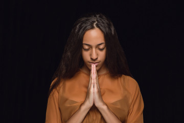 Close up portrait of young african-american woman isolated on black studio background. Photoshot of...