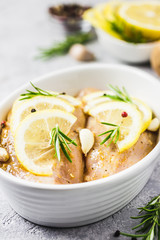 Lemon rosemary garlic raw chicken breasts in baking dish, ready for cooking. Selective focus, space for text.