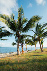 Fototapeta na wymiar beautiful girl near palm trees in front of the sea in Sanya