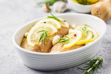 Lemon rosemary garlic raw chicken breasts in baking dish, ready for cooking. Selective focus, space for text.