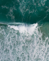 Aerial view of a waves crashing and rolling in the ocean.
