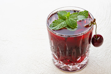 Glass of Cherry Juice with Mint and Ice, Close Up on White Background
