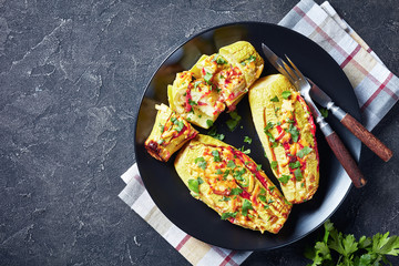Stuffed courgettes served on a black plate