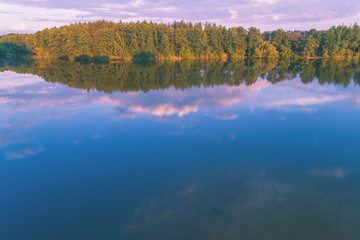 Fototapeta premium The magical sunrise over the lake. Rural landscape