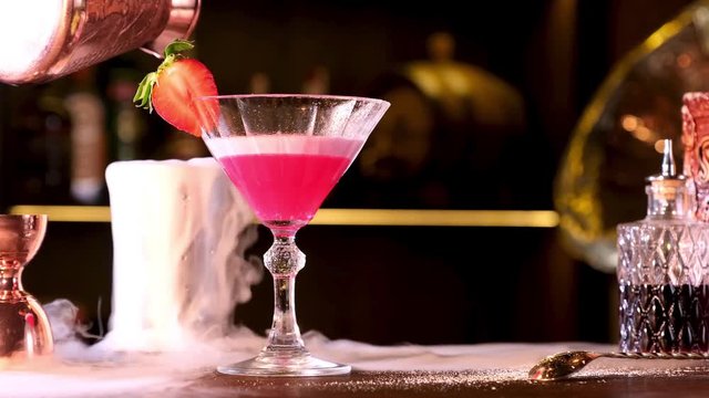 classic cocktail clover club in a nightclub smoke at the bar counter. Steam is blowing slowly away and a glass with iced drink standing on the table