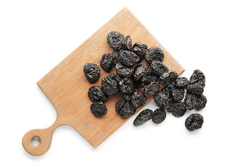 Board with tasty prunes on white background