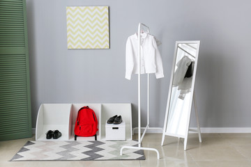 Stylish school uniform, backpack and shoes in room