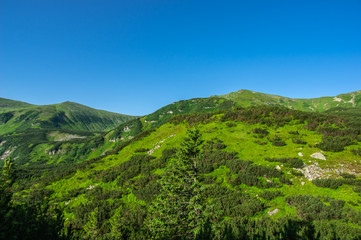 Green hills against the blue sky in the mountains