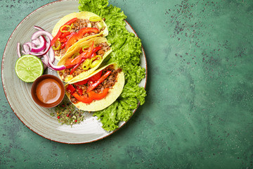 Plate with tasty fresh tacos on color background