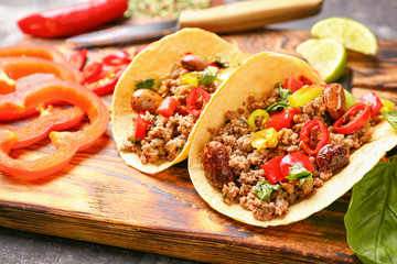 Tasty fresh tacos on wooden board, closeup