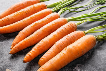 Tasty fresh carrot on dark background