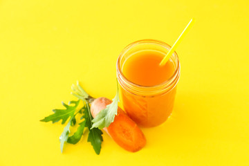 Jar of tasty carrot juice on color background