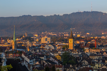 Fototapeta na wymiar sunrise view on churches, roofs and Uetliberg of Zurich city