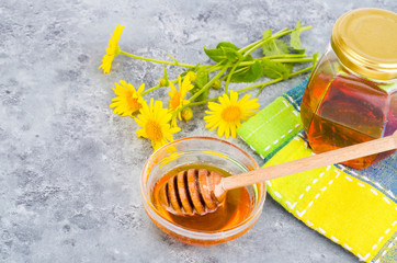 Aromatic flower honey, wild flowers on gray background. 