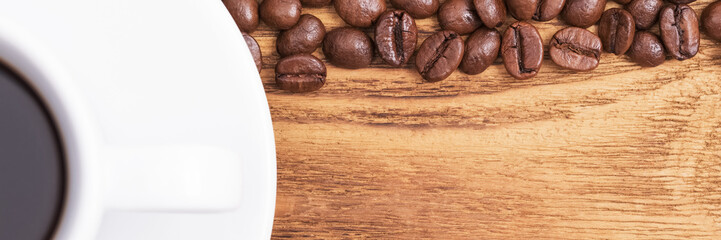Coffee bean. On the background of wooden boards a cup of coffee and scattered coffee beans. Layout. Flat lay.