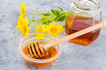 Aromatic flower honey, wild flowers on gray background. 