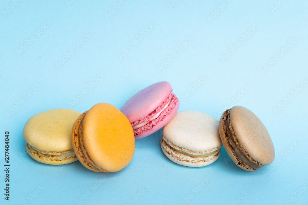 Wall mural top view of tasty colorful macaroons on blue background