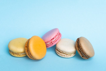 Top view of tasty colorful macaroons on blue background