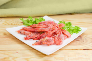 Fototapeta na wymiar Frozen shrimps on dish close-up in selective focus