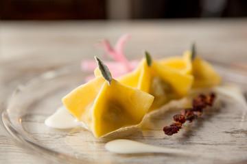 Fagottini ripieni di magro e stracchino in salsa di taleggio, salvia e bacon croccante