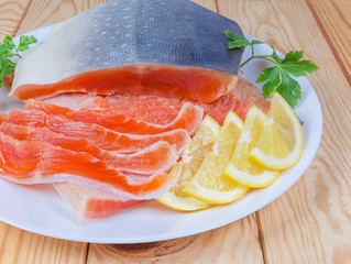 Partly sliced salted arctic char on dish on rustic table