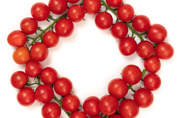 A branch of red cherry tomatoes on a white background. Small and juicy vegetable is rich in vitamins and trace elements. Healthy food. Fresh and organic vegetables. Raw food
