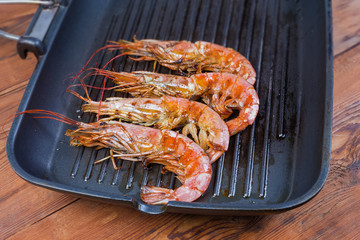Grilled ocean king prawns on the grill pan close-up