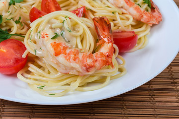 Cooked Spaghetti pasta with shrimp tails and cherry tomatoes closeup