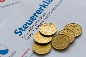 several golden coins on Swiss tax declaration form, Zurich