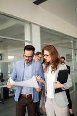 Confident business people reviewing project in office