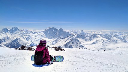 Fototapeta na wymiar Girl with snowboard siting at the Caucasus Mountains,Elbrus