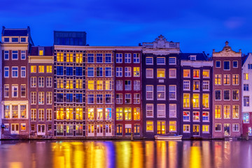 Fototapeta premium Typical old dutch houses over canal with reflections at twilight in Amsterdam, North Hilland, Netherlands. Amsterdam postcard.