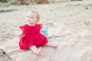 Beautiful little baby girl sitting on the beach