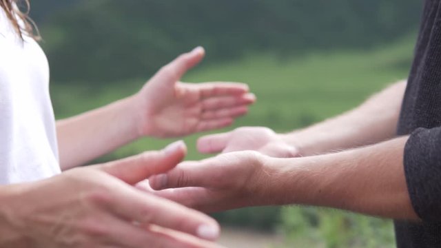 Hand in hand against the backdrop of mountains. Tenderness of hands in love. Slow motion