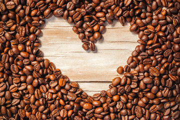 frame with roasted coffee beans in the shape of a heart , can be used as a background