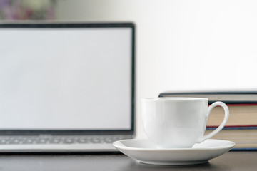Fototapeta na wymiar Coffee cup and laptop on table