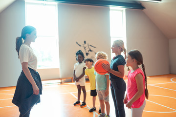 School children playing ball with their sports teacher.